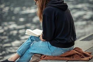 woman reading by a body of water