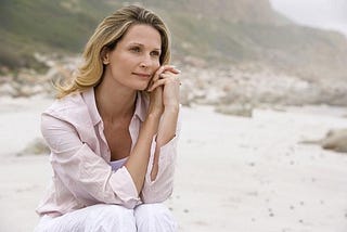 Lady by herself, pondering, at a lonely beach