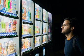 A man choosing a drink from 5 different Japanese vending machines