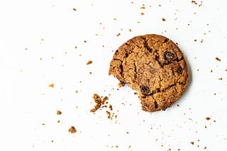 An image of a chocolate chip cookie with a bite taken off.