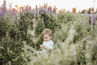 child in field being curious