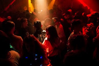 A ray of light illuminating a woman in the middle of a dance floor