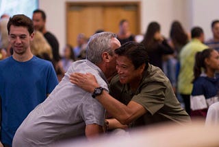 Men in a meeting hugging