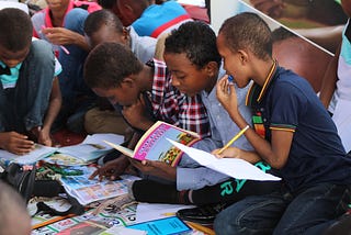 Students looking at magazines in the classroom.