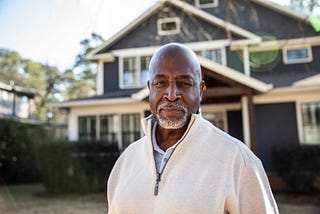 Portrait of senior man in front of his house