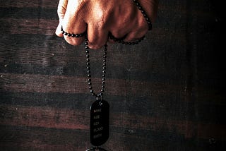 Military Dog tag held by Man