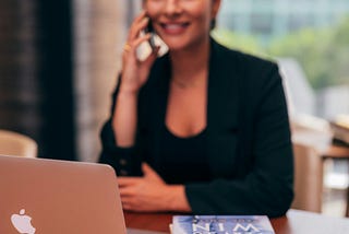woman on a phone sitting at a desk