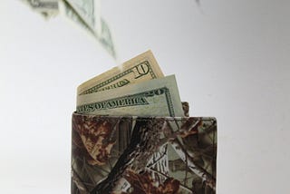 A wallet with money flying out of it.