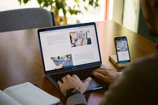 Rear shot of person using a laptop on a table.