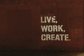 A mural with writings on it that says live work create