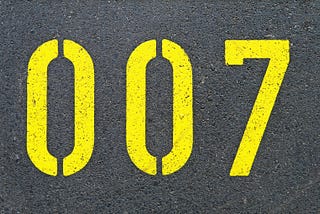 The numbers “zero zero seven” — aka double-oh-seven — are stenciled large in yellow paint against a black background.