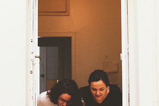 Two women looking down out of a window