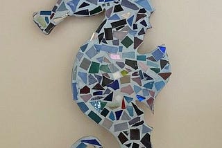 Photo of a seahorse mosaic, filled with blue and green glass tiles
