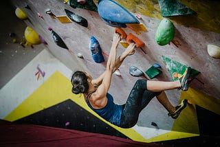A Woman Walks Out of a Climbing Gym
