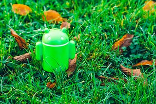 Android figurine in green grass