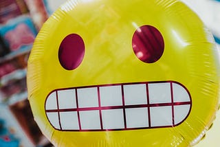 Helium balloon of an emoji face grinning