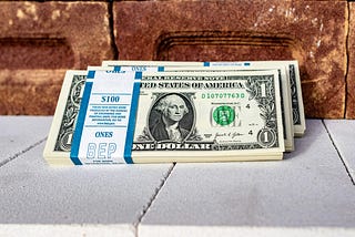 Multiple stacks of dollar bills in $100 bundles