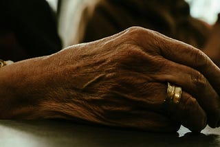 Close up of an elderly women’s hand showing what appears to be a wedding band.