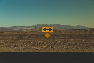 A sign with arrows pointing left and right in the desert