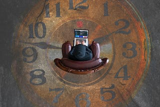 Top view of a person sitting in a chair with their laptop. The floor looks like an old clock face.