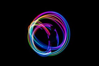 Time-lapse photography, colourful lights in a circle on a black background