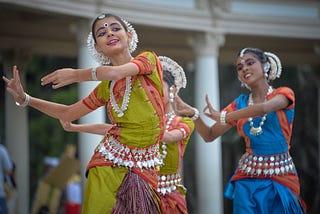 Indian women with different shades of skin performing a dance.