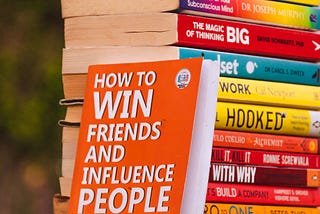 A stack of “positive thinking” books on a lawn.