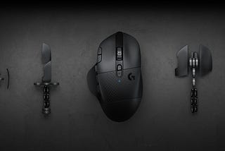 Photograph of a gaming mouse in the center with some of its parts on either side.