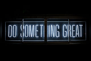 Dark LED-Sign saying in light blue font “Do something great”