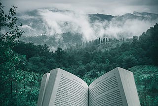 book pages with a picturesque mountain landscape in the background