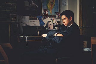 A Harvard freshman sleeping on a chair in a dormitory room.