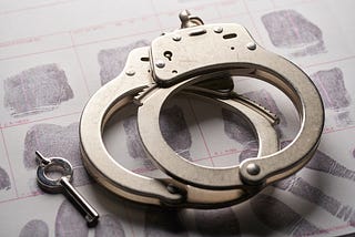 A pair of locked handcuffs on a table.