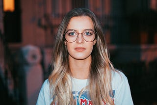 Portrait of a woman with glasses looking directly at the viewer.