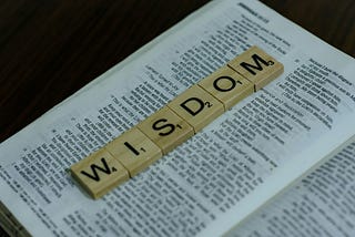 The Word “WISDOM” in block alphabets on the sheet of a book.