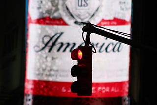 a street sign that says America, with right traffic light