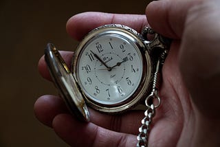 Imagem de pessoa encarando um relógio de ponteiros