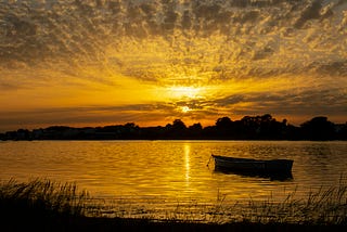 Boat in the waters overlooking the setting sun