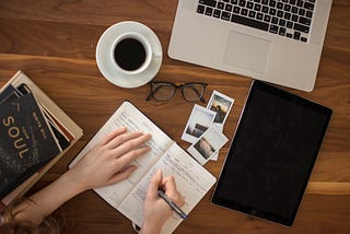 Writer checking her notebook on a crowded tabletop