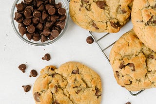 Chocolate chip cookies next to a bowl of chocolate chips.