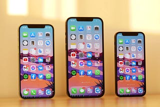 All three iPhone 12 models side by side on top of desk