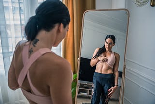 A women viewing her belly in the mirror