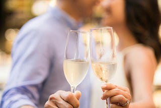 A couple tossing wine glasses for the camera