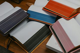 a stack of blank open journals, waiting to be written in