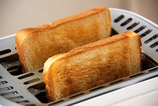 Photo of two slices of toasted bread in toaster.