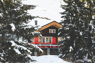 A house behind snowy trees