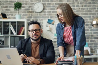 Woman hiring a ghostwriter. A man and woman working in an office