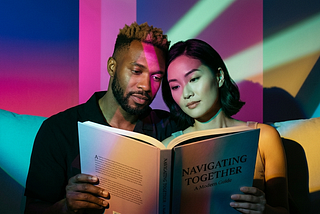 An interracial couple reading a relationship book together