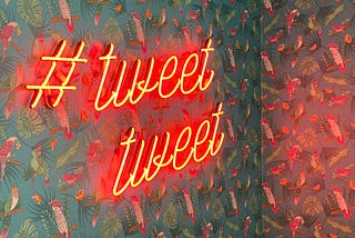 Orange neon sign with a hashtag reading #tweet tweet