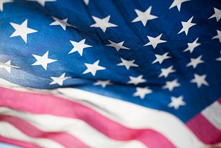 Partial view of an American flag, showing the stars and stripes.