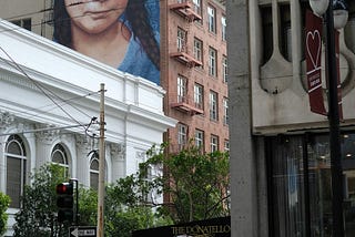 Graffiti of Greta Thunberg on the building of a busy Western Street